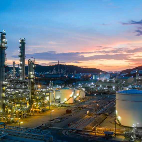 Aerial view oil and gas tank with oil refinery background at night, Glitter lighting of petrochemical plant with night, Manufacturing of petroleum, Products tank in petrochemical plant.